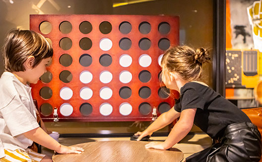 boy and girl playing large sized connect 4 game